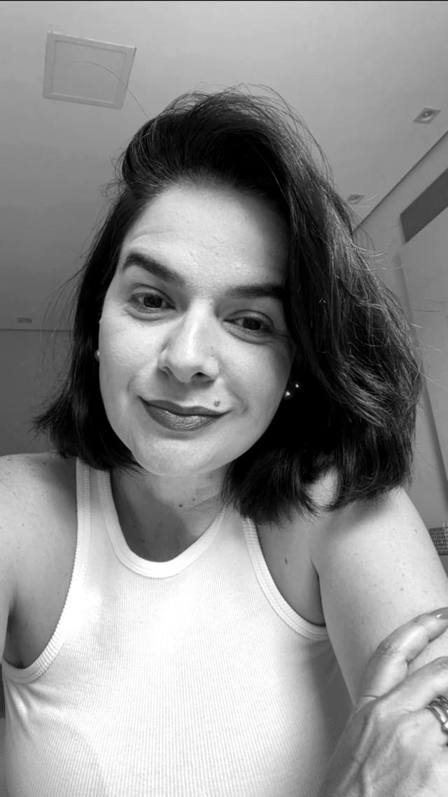Tahís de regata branca, sorriso direto